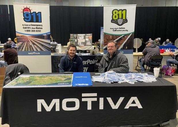 Motiva employees sit at a Motiva booth to give 811 information.