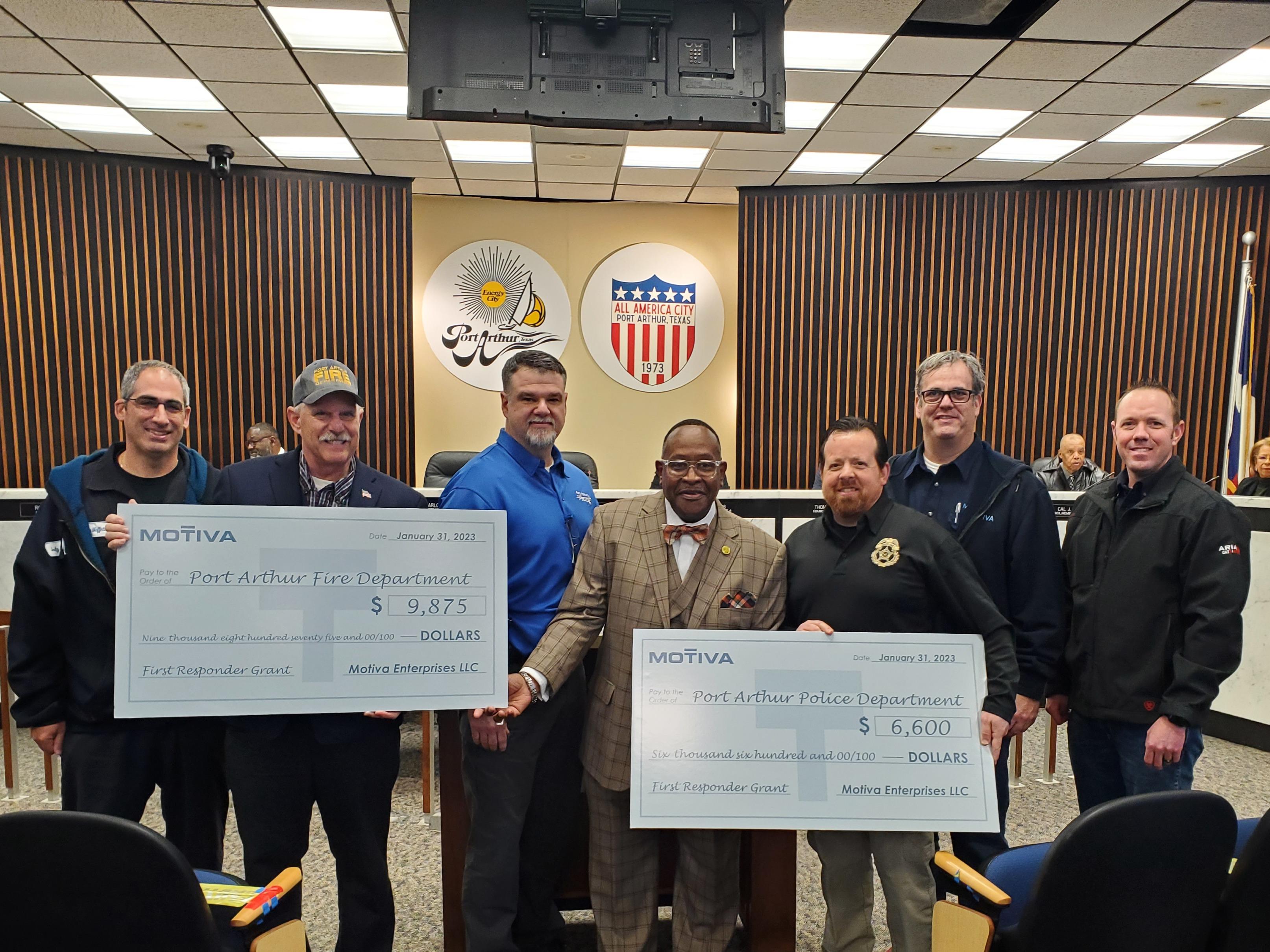 The Port Arthur Fire Department and Police Department hold up grant checks received from Motiva through Motiva's First Responder Grant Program.