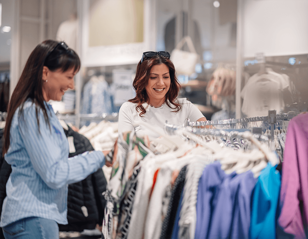 Two women shopping for clothing.