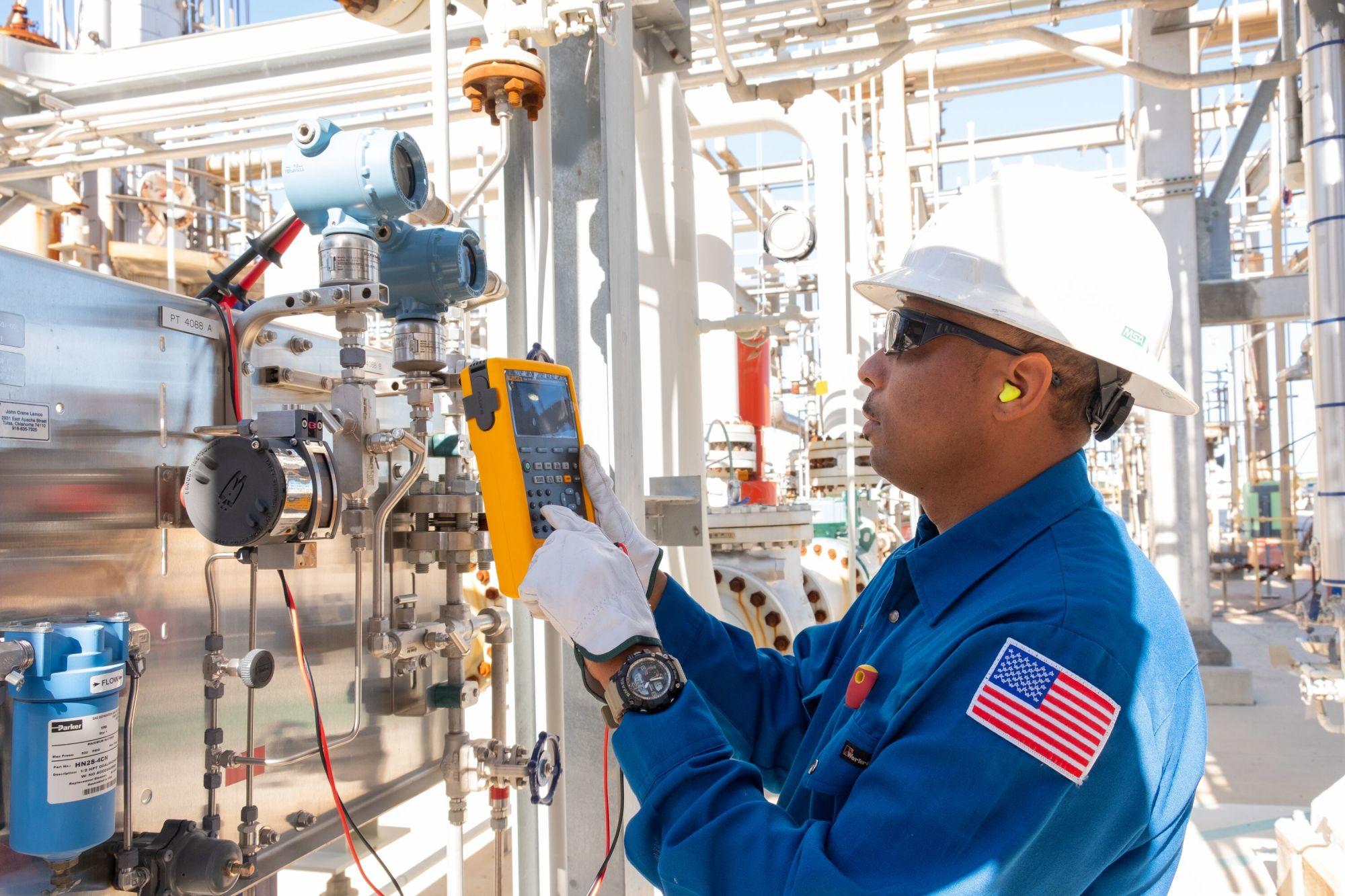 Employee monitors chemicals plant equipment.