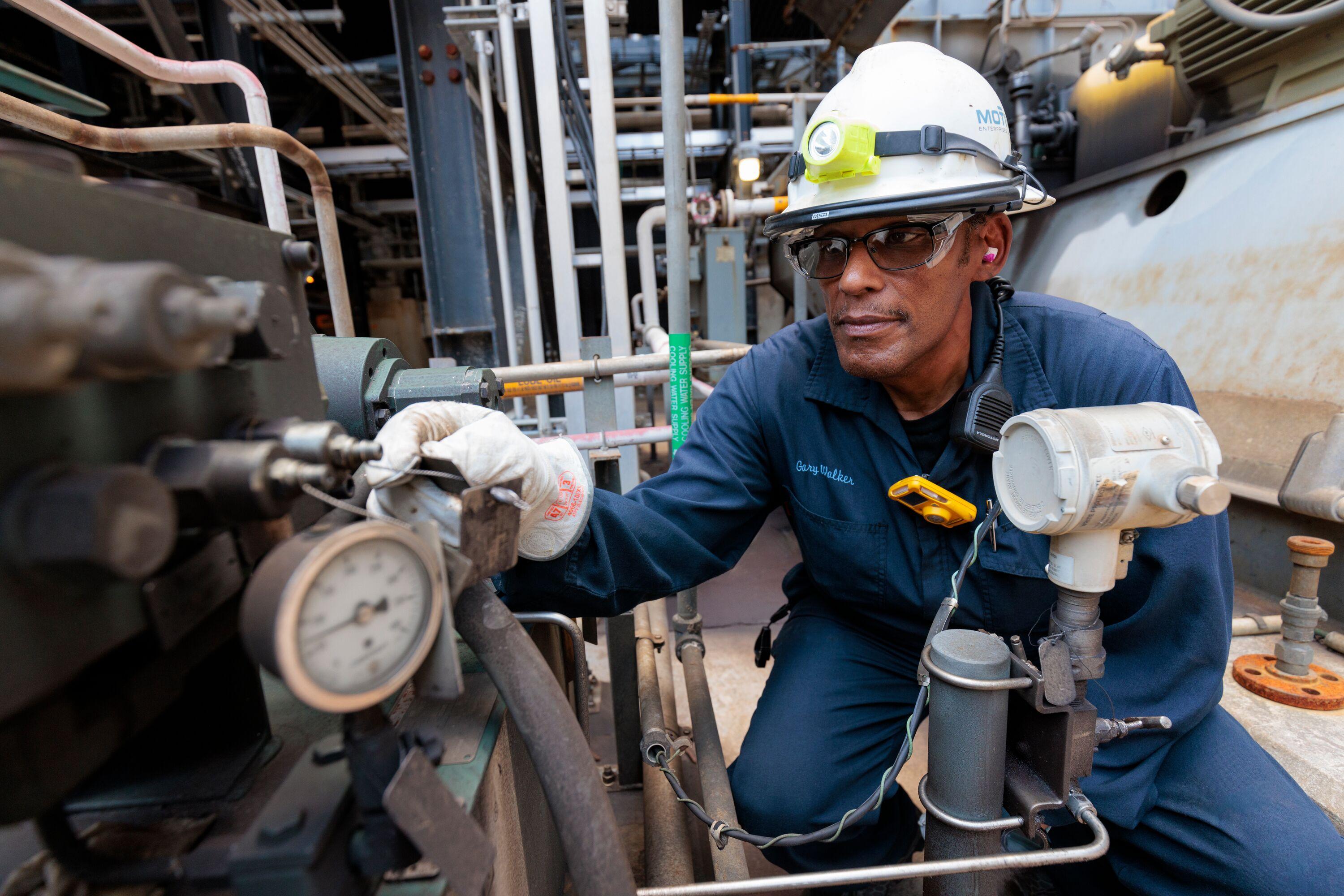 Motiva employee inspecting piece of equipment.