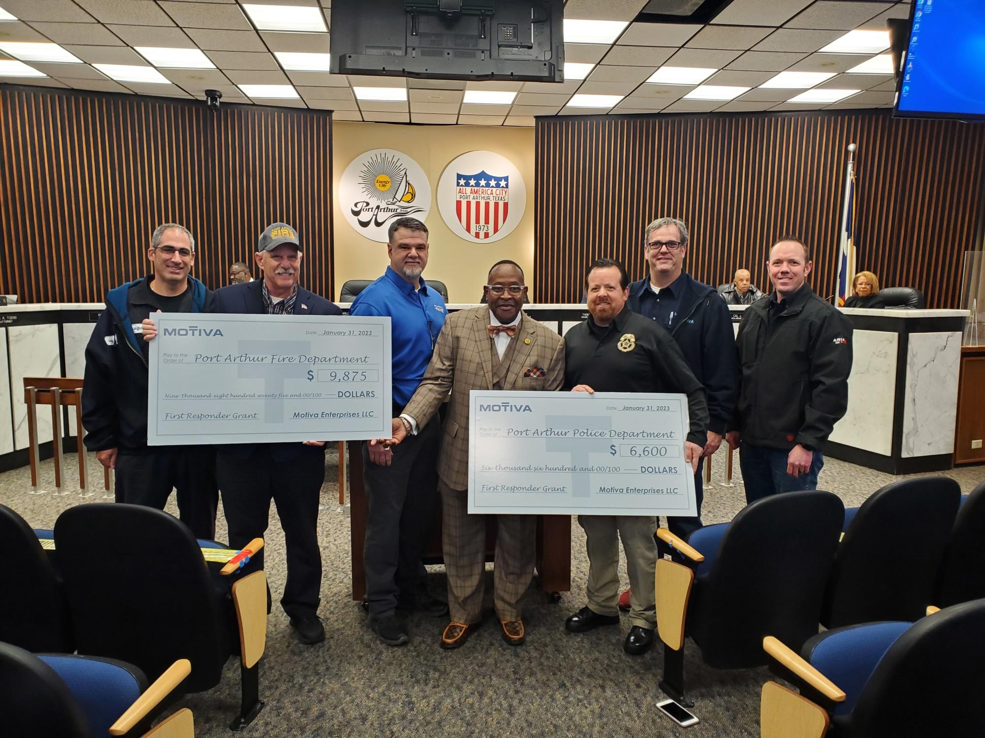 The Port Arthur Police Department and Port Arthur Fire Department hold up checks as grant recipients from Motiva's First Responder Grant Program.