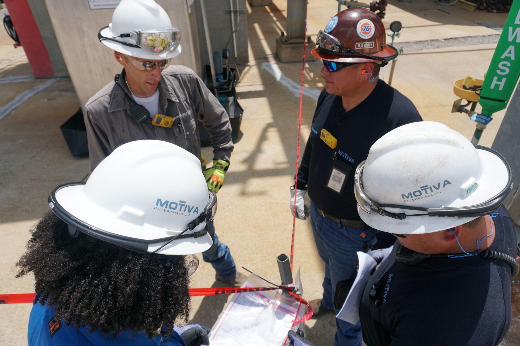 Group of four people reviewing a permit.