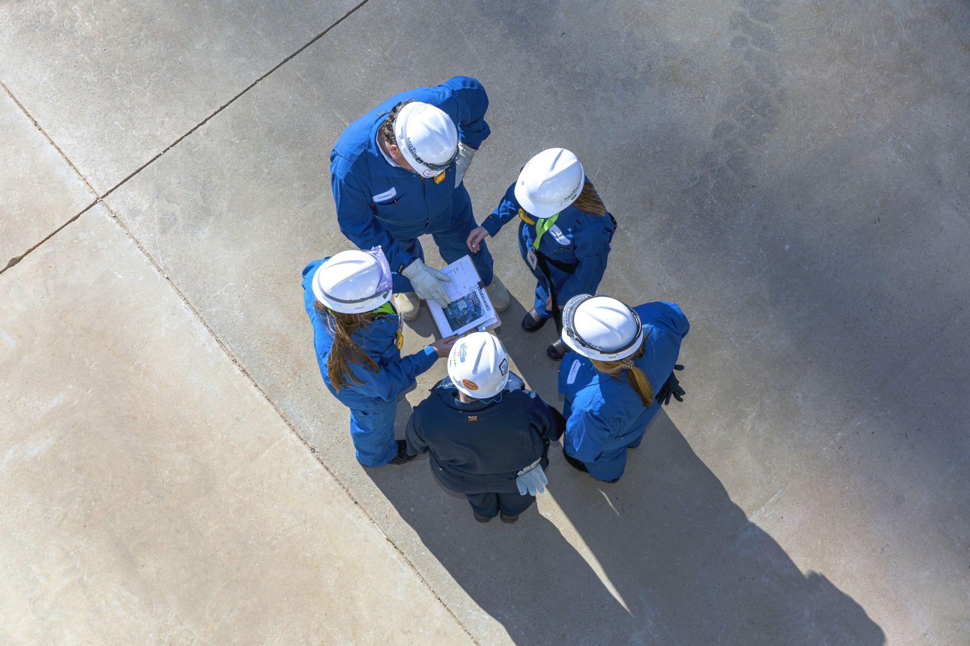 A group of five people looking at a sheet of paper